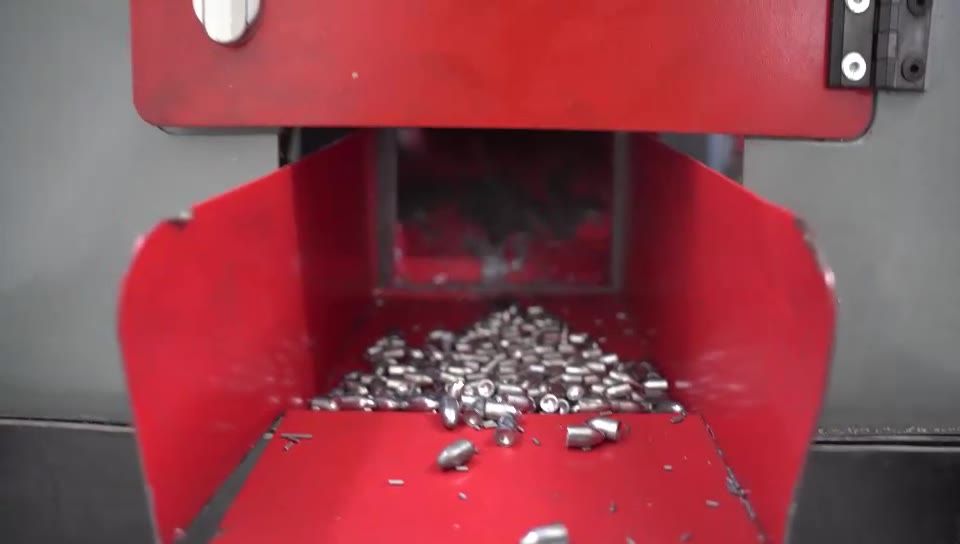Freshly pressed lead cores in a red machine hopper