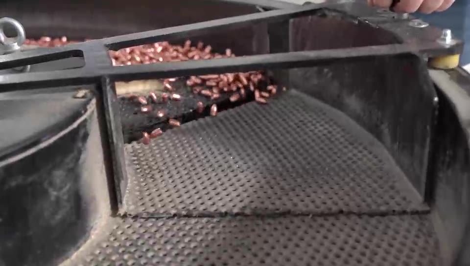 Projectiles moving across a perforated vibratory deck